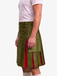 A man wearing a green faux-leather kilt with red pleated side panels, paired with a white t-shirt and white socks, shown from the chest down against a light gray background.