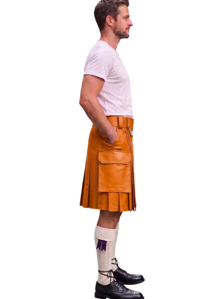 A man shown in profile wearing a tan leather kilt, a light pink t-shirt, white socks, and black shoes, isolated on a white background.