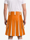 An orange faux-leather pleated kilt with white contrast stitching and white belt loops, shown on a model from the back wearing a white t-shirt.