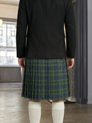 Person wearing a black jacket and green plaid kilt indoors.