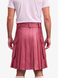 A person shown from the back wearing a dusty rose pink pleated faux leather kilt with side cargo pockets, paired with a light pink t-shirt and white socks, against a light gray background.