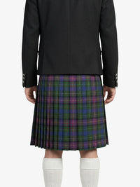 Person wearing a black jacket and plaid kilt on a white background