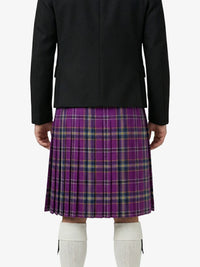 Person wearing a black jacket and purple plaid skirt on a white background