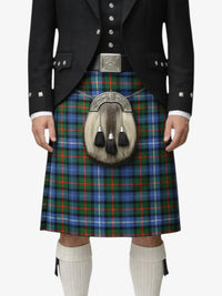 Person wearing a traditional Scottish kilt with a tartan pattern on a white background