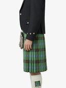 Person wearing a black jacket and green plaid kilt on a white background