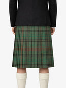 Green plaid kilt worn with a black jacket on a white background
