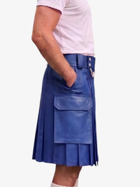 A person wearing a blue pleated leather kilt with a belt and front flap pocket, paired with a light pink t-shirt, shown from the side against a plain light background.