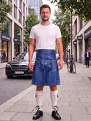 A man stands on a city sidewalk wearing a white crew-neck t-shirt and a blue leather kilt with a waist strap, paired with cream knee-high socks and black leather shoes. A black Mercedes-Benz car and a bicycle are visible in the background of the street scene.