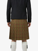 Person wearing a black jacket and plaid kilt on a white background
