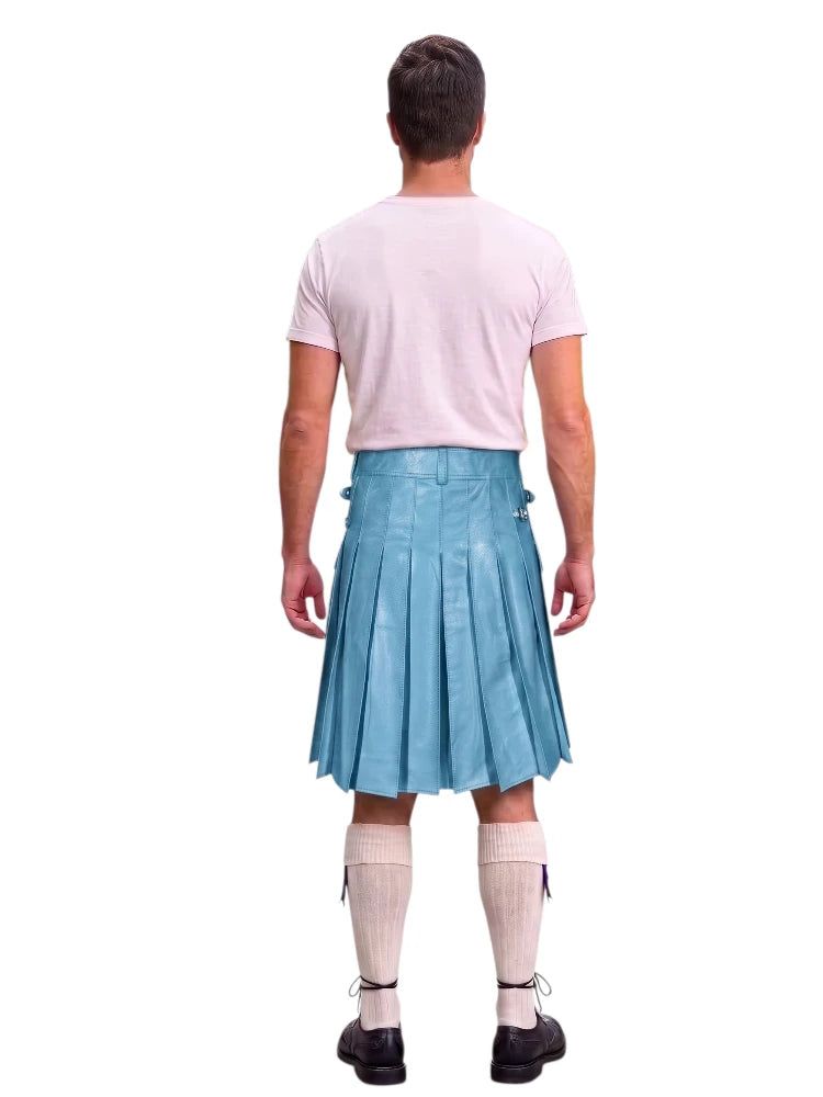 A man shown from the back wearing a light blue pleated kilt, a light pink t-shirt, cream-colored knee-high socks, and black shoes, against a solid white background.