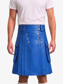 A person wearing a bright blue faux-leather kilt with silver-tone metal buttons and side flap pockets, paired with a white t-shirt against a plain light background.
