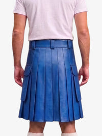 A man wearing a bright blue pleated faux-leather kilt with side cargo pockets, paired with a light pink t-shirt, shown from the back against a light gray background.