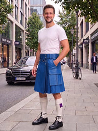 A man stands on a city sidewalk wearing a bright blue leather kilt, a white t-shirt, white knee-high socks, and black leather shoes. The background shows a street with buildings, a parked black Mercedes, and a bicycle.