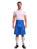 A man modeling a bright blue faux-leather kilt with a front flap pocket and silver buckle, styled with a white t-shirt, beige knee-high socks, and black lace-up boots against a plain white background.