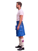 A man shown in profile wearing a blue leather kilt, a white t-shirt, white socks, and black shoes, standing against a solid white background.