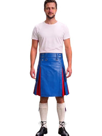 A man modeling a bright blue faux-leather kilt with red side panels and silver metal hardware, styled with a white t-shirt, cream knee-high socks, and black lace-up boots against a plain white background.
