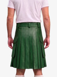 A person shown from the back wearing a dark green pleated leather kilt with side cargo pockets, paired with a light pink t-shirt and white socks, against a plain light gray background.