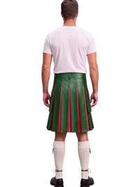 A man viewed from behind wearing a green pleated kilt with red vertical pleats, a light pink t-shirt, white knee-high socks, and black shoes, against a plain white background.