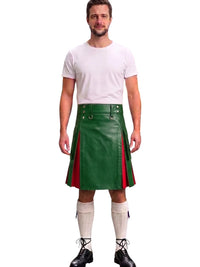 A man modeling a green leather kilt with red side panels, paired with a white t-shirt, white knee-high socks, and black lace-up boots, against a plain white background.