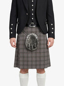 Person wearing a black jacket with decorative buttons and a gray plaid kilt on a white background