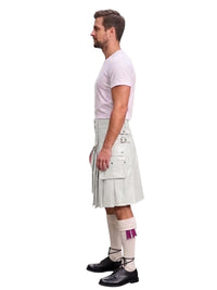 A man shown in profile wearing a white pleated kilt with multiple flap pockets, a light pink t-shirt, white socks with a purple accent, and black leather shoes, set against a plain white background.