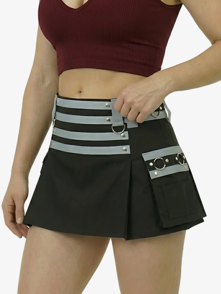 Person wearing a black skirt with a gray belt featuring multiple pockets and straps on a white background