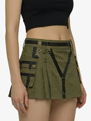 Green skirt with black suspenders worn by a person on a white background