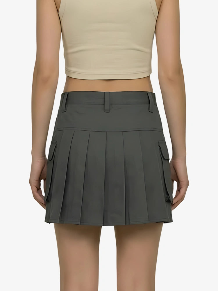 Person wearing a gray pleated skirt with pockets on a white background