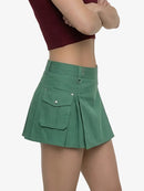 Green pleated skirt worn by a person on a white background