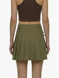 Person wearing a brown crop top and green pleated skirt on a white background
