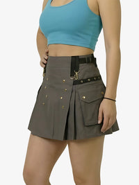 Person wearing a gray skirt with grommets and a blue top on a white background