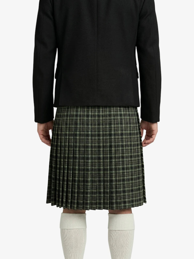 Person wearing a black jacket and plaid kilt on a white background
