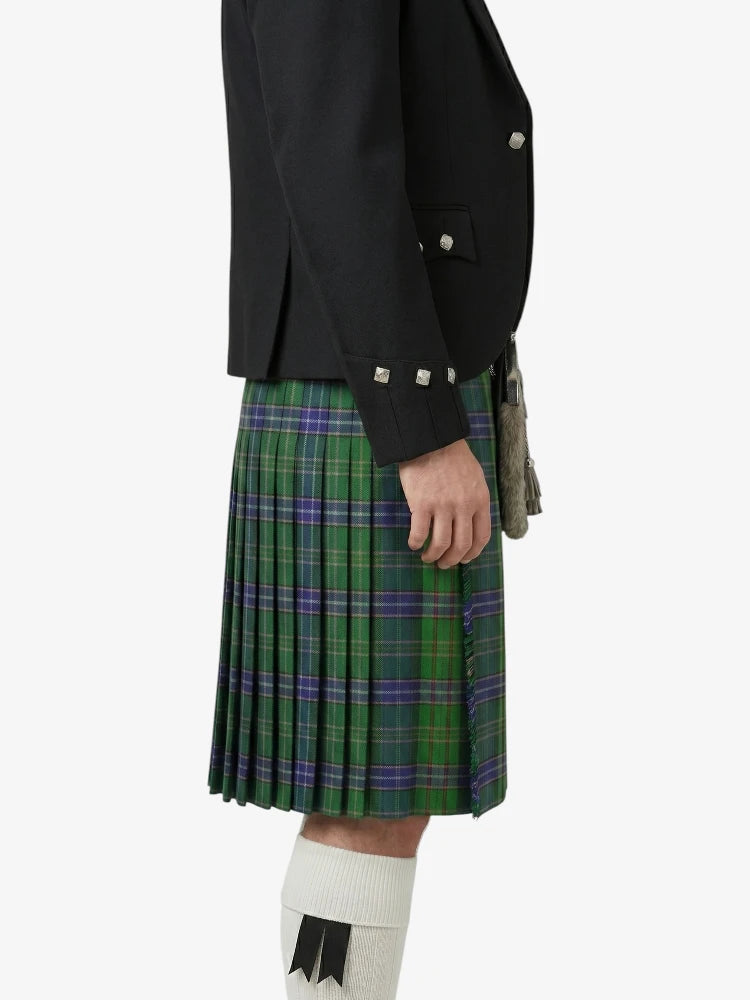 Person wearing a black jacket and green plaid kilt on a white background